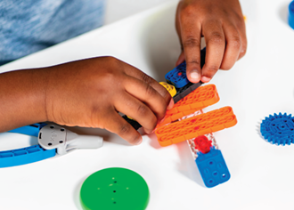Niños armando robots en una mesa de trabajo