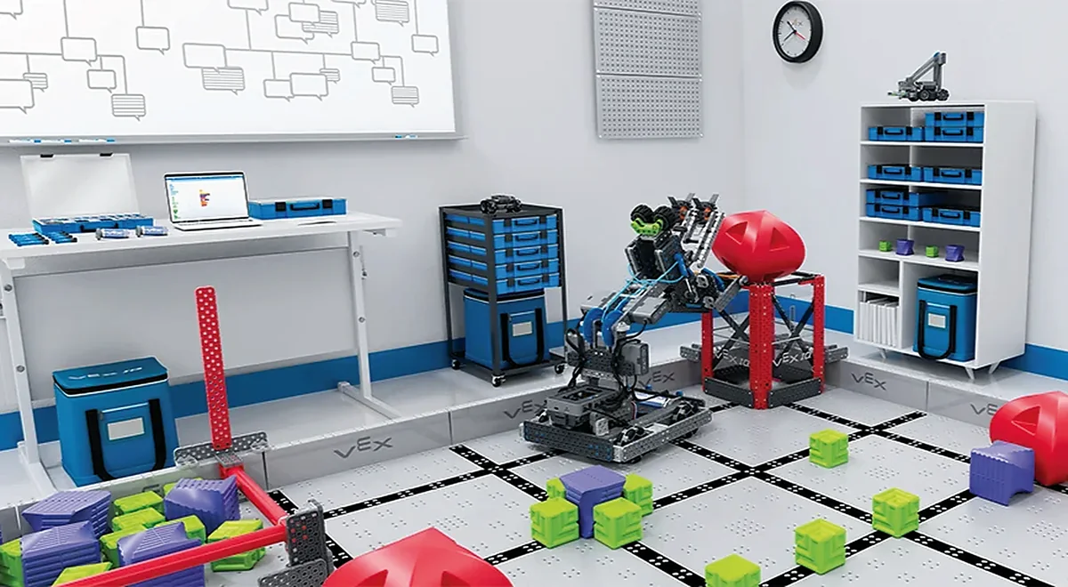 Aula STEAM de robótica equipada con kits VEX Robotics, campo de competencia y estaciones de trabajo