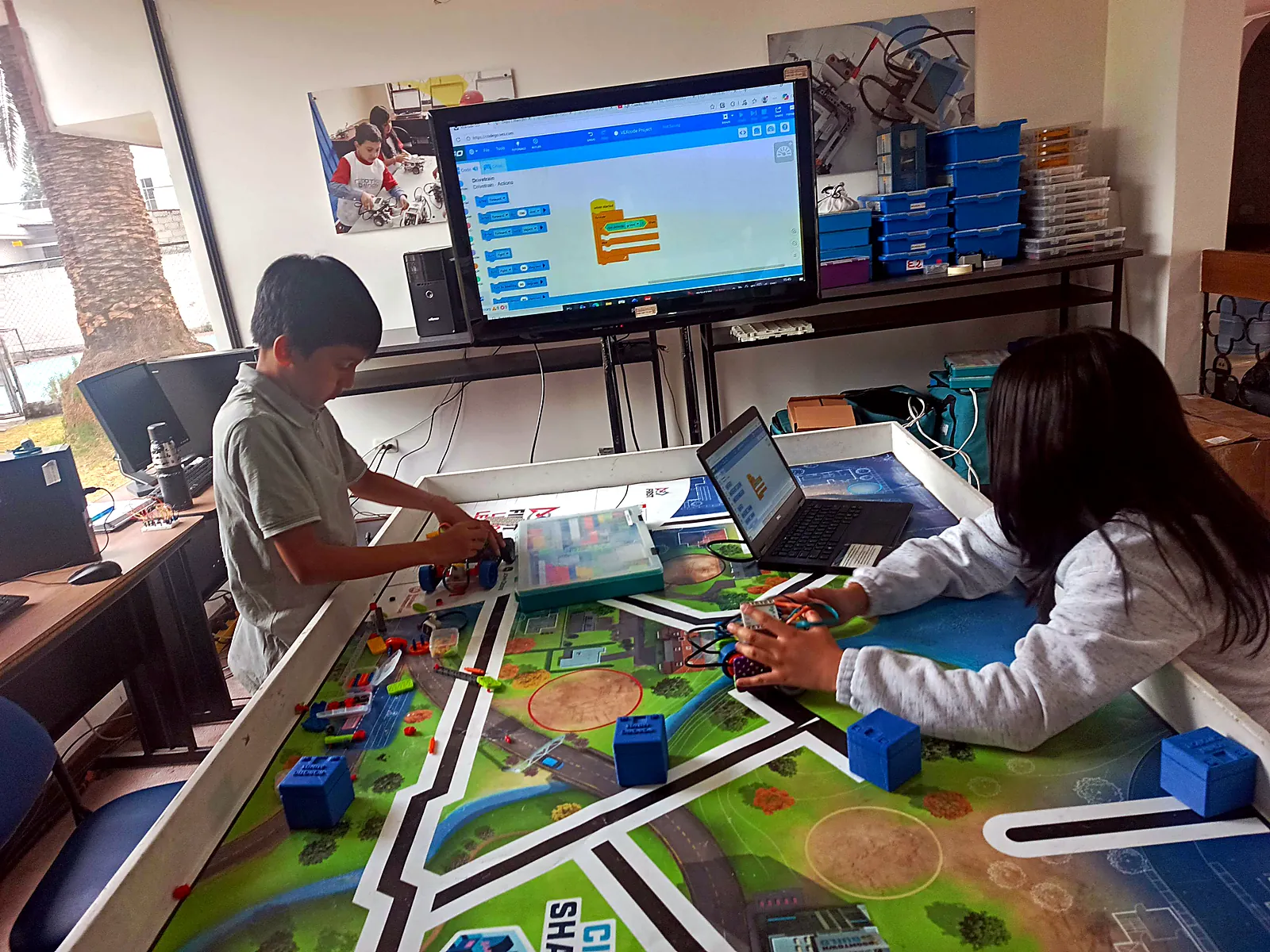 Niños programando robots sobre una pista de competencia